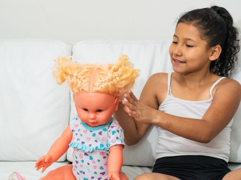 Trẻ chơi với người bạn búp bê